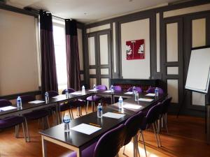 a meeting room with tables and purple chairs at Kyriad Chalon-Sur-Saone Centre in Chalon-sur-Saône