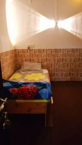 カリンポンにあるHeaven Valley Homestayのレンガの壁の客室の小さなベッド1台分です。