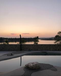 a reflection of a sunset in a pool of water at Casa Rural encantos de Orellana in Navalvillar de Pela +60 photos