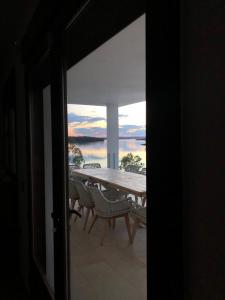 a table and chairs on a balcony with a view of the water at Casa Rural encantos de Orellana in Navalvillar de Pela