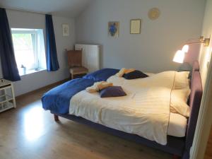 ein Schlafzimmer mit einem großen Bett in einem Zimmer mit einem Fenster in der Unterkunft De Aventurijn in Riemst