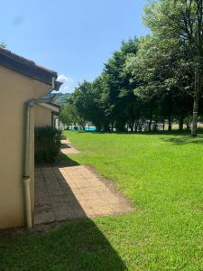 a path in a grassy field next to a building at Le Petit Bois 46 in Leyme
