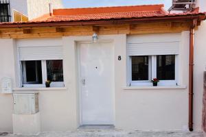 a white house with two windows and a white door at Rosa HOME, Casa completa independiente in Pozuelo de Alarcón