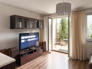 Televízia a/alebo spoločenská miestnosť v ubytovaní APARTAMENT POD GWIAZDAMI, z dwoma ogródkami i dwoma tarasami