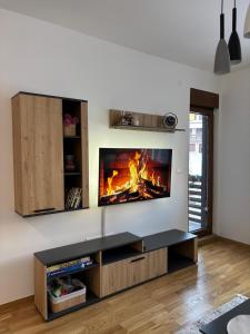 a living room with a fire in the wall at Tanasković Home Zlatibor in Zlatibor