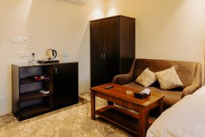 a room with a bed and a couch and a table at فندق الردهة in Al Ḩawīyah