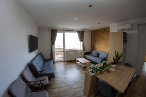 a living room with a couch and a table at Apartmán u Kulíška in Prievidza