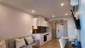 een woonkamer met een bank en een keuken bij Premium Twin King Ensuite plus Double sofa bed - Mcity shopping center - Clayton - Monash University and Hospitals - Super Fast Wifi - Free Parking & Amenities - Complementary drinks & coffee in Clayton North