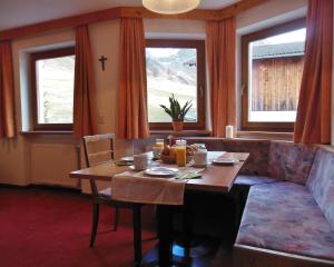 uma sala de jantar com uma mesa e uma cruz na parede em Residence Alpin em Melago