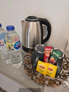 a counter top with a tea pot and water at ฮัก ณ หนองคายโคซี่วิลล์ Hug Na Nongkhai Cozy Ville in Nong Khai