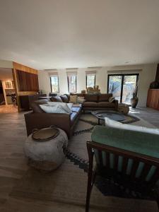 a living room with couches and tables and windows at Boulder Bungalow in Prescott