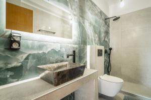 a bathroom with a sink and a toilet at Nidri Hills Villa in Nydri +23 photos