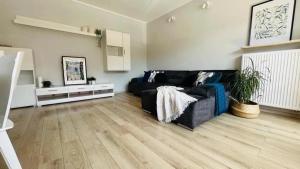 a living room with a black couch and a wooden floor at Premium Gniezno in Gniezno