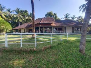 a white fence in front of a house at Bharathapuzha resort in Kārakkād