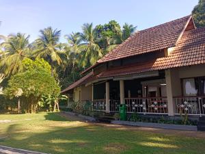 a house with palm trees in the background at Bharathapuzha resort in Kārakkād +1 photo