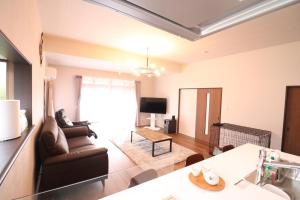 花卷市デコピンハウス的客厅里有一张沙发和一张桌子。