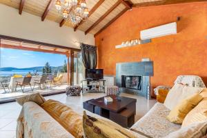 a living room with a couch and a fireplace at Nidri Hills Villa in Nydri