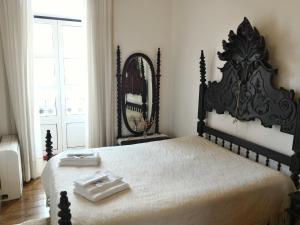 - une chambre avec un grand lit et un miroir dans l'établissement Apartment Rua Corpo de Deus in Coimbra, à Coimbra