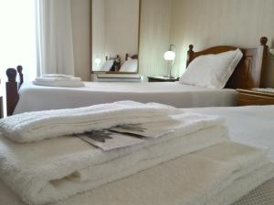 
a white towel laying on top of a white bed at Apartment Rua Corpo de Deus in Coimbra in Coimbra
