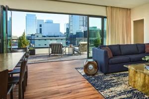 ein Wohnzimmer mit Couch und großem Fenster in der Unterkunft The Bankers Alley Hotel Nashville, Tapestry Collection by Hilton in Nashville