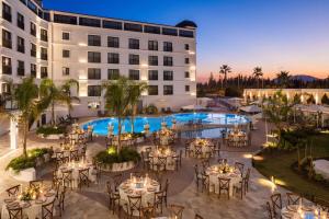 an image of a hotel with tables and chairs in front of a building at Ramada by Wyndham Dalaman in Dalaman