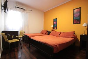 Un dormitorio con dos camas y una ventana. en Hotel Ancon, en Buenos Aires