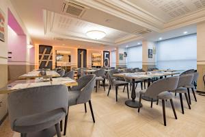 a restaurant with tables and chairs in a room at Just Hotel Saronno in Saronno