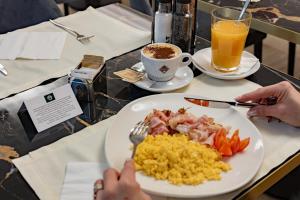 a table with a plate of breakfast food and a cup of coffee at Just Hotel Saronno in Saronno +105 photos