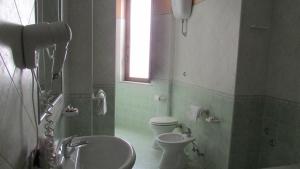 
a bathroom with a toilet, sink, and tub at Hotel Al Palazzetto Set Fair in Ospedaletto dʼAlpinolo
