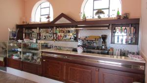 a bar in a restaurant with a counter and windows at Hotel Al Palazzetto Set Fair in Ospedaletto dʼAlpinolo