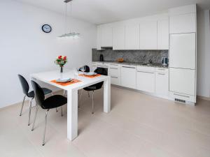 cocina blanca con mesa blanca y sillas en Apartments AnaMar, en Rovinj