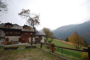 a large house in a field with a fence at Chalet Valentina in Madonna di Campiglio +6 photos