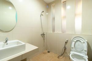 a bathroom with a sink and a toilet and a mirror at Family Only Pool & Mountain View Modern Bamboo Villa - De Reiz Ethnic Syariah in Bandung +11 photos