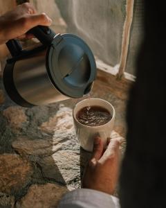 a person is pouring coffee into a cup at the suwgra-Al-Jabal Al-Akdar in Sūkirah