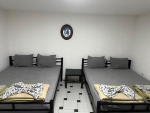 two beds in a room with a clock on the wall at Apartments 64 in Star Dojran