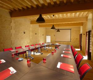 a large conference room with long tables and red chairs at Le Clos Chavigny in Lerné +49 photos