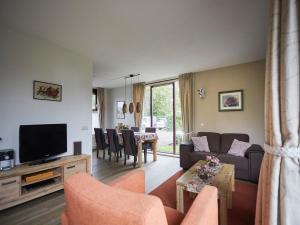 a living room with a couch and a tv at Holiday Home in Zeeland near Beaches in Heinkensand