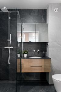 a bathroom with a sink and a shower at Metropolis Design Apartments in Kraków +22 photos