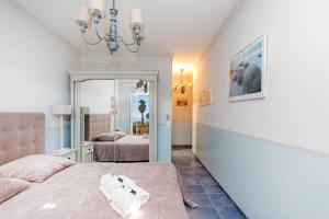 a bedroom with a bed and a chandelier at Jolie bastide 5 chambres avec belle vue mer in Mandelieu-la-Napoule +19 photos