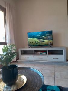 a living room with a tv and a table at ReMo in Sandton