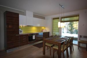 a kitchen with a wooden table and a dining room at Marina Holiday Honka Village Apartments in Imatra
