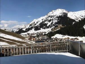 a snow covered mountain with a town and a bridge at Penthouse Wöster in Lech am Arlberg