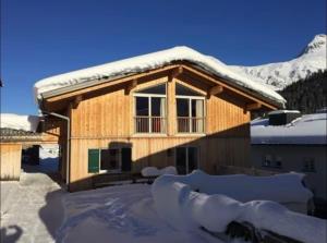 a house covered in snow with a roof at Penthouse Wöster in Lech am Arlberg