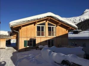 a house covered in snow with a roof at Appartement Kriegerhorn in Lech am Arlberg