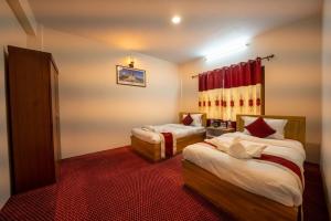 a bedroom with two beds and a red carpet at Mega Sweet Home Apartment in Bālāju