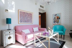 a living room with a pink couch and a table at Singular Corral de San José in Seville