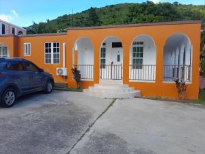 a car parked in front of a orange building at Abigail Diamond 2 bedroom apt Near Nanny Cay marina in Hannah