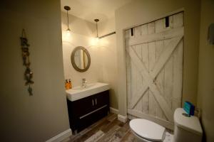 a bathroom with a white toilet and a sliding barn door at Shawnigan Suite B & B in Shawnigan Lake