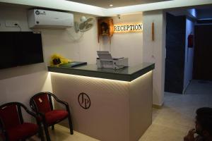 a room with a reception counter with two chairs at Hotel Deluxe in Rānchī