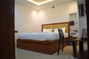 a bedroom with a bed and a chair and a table at Hotel Deluxe in Rānchī